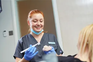 A hygienist demonstrating brushing technique on a model