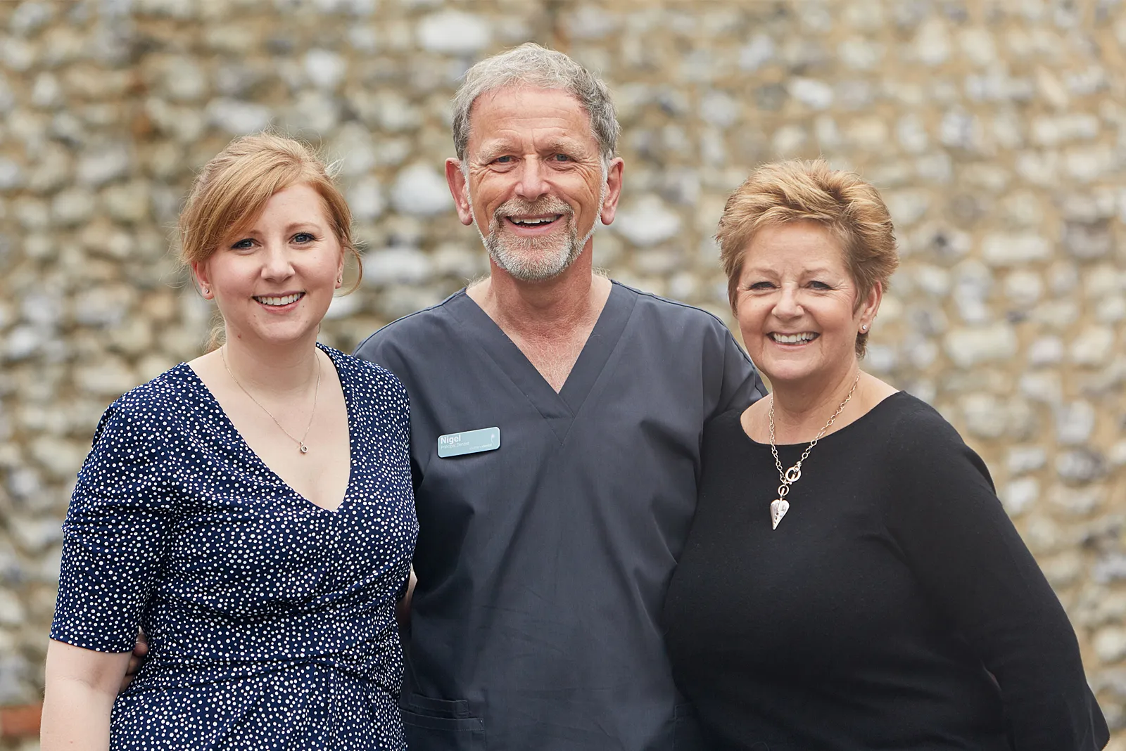 Three members of the South Lane Dental team smiling outside the practice